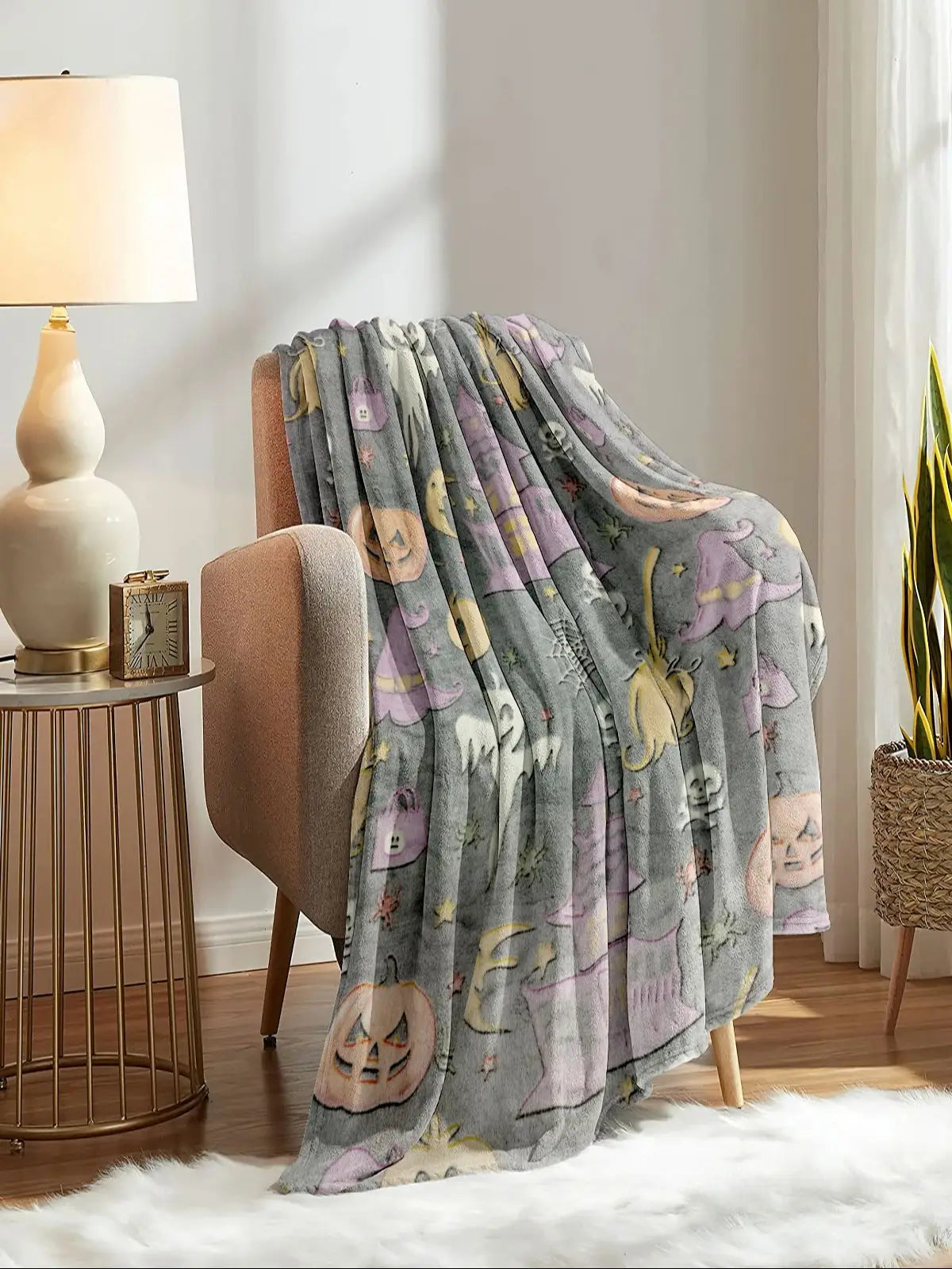 Grau-lila gemustertes Korallen-Fleece-Decke über einem beigen Stuhl in einem hellen Raum.