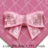 Pink sequin bow patches for DIY crafts shown on a pink cutting mat