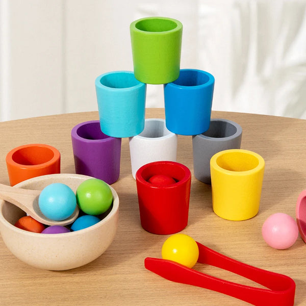 A collection of colorful wooden stacking cups in various shades of green, blue, purple, and yellow on a wooden surface.