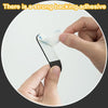 A hand is applying a piece of white adhesive tape to a black hook, demonstrating strong backing adhesive.