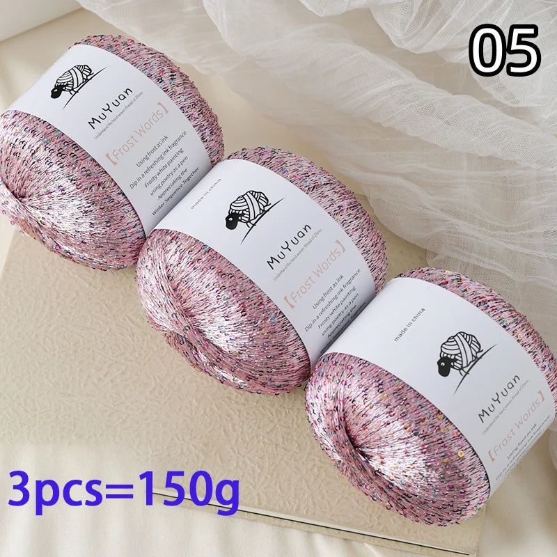 Three skeins of pink glitter yarn labeled MuYuan Frost Words are displayed on a light surface.