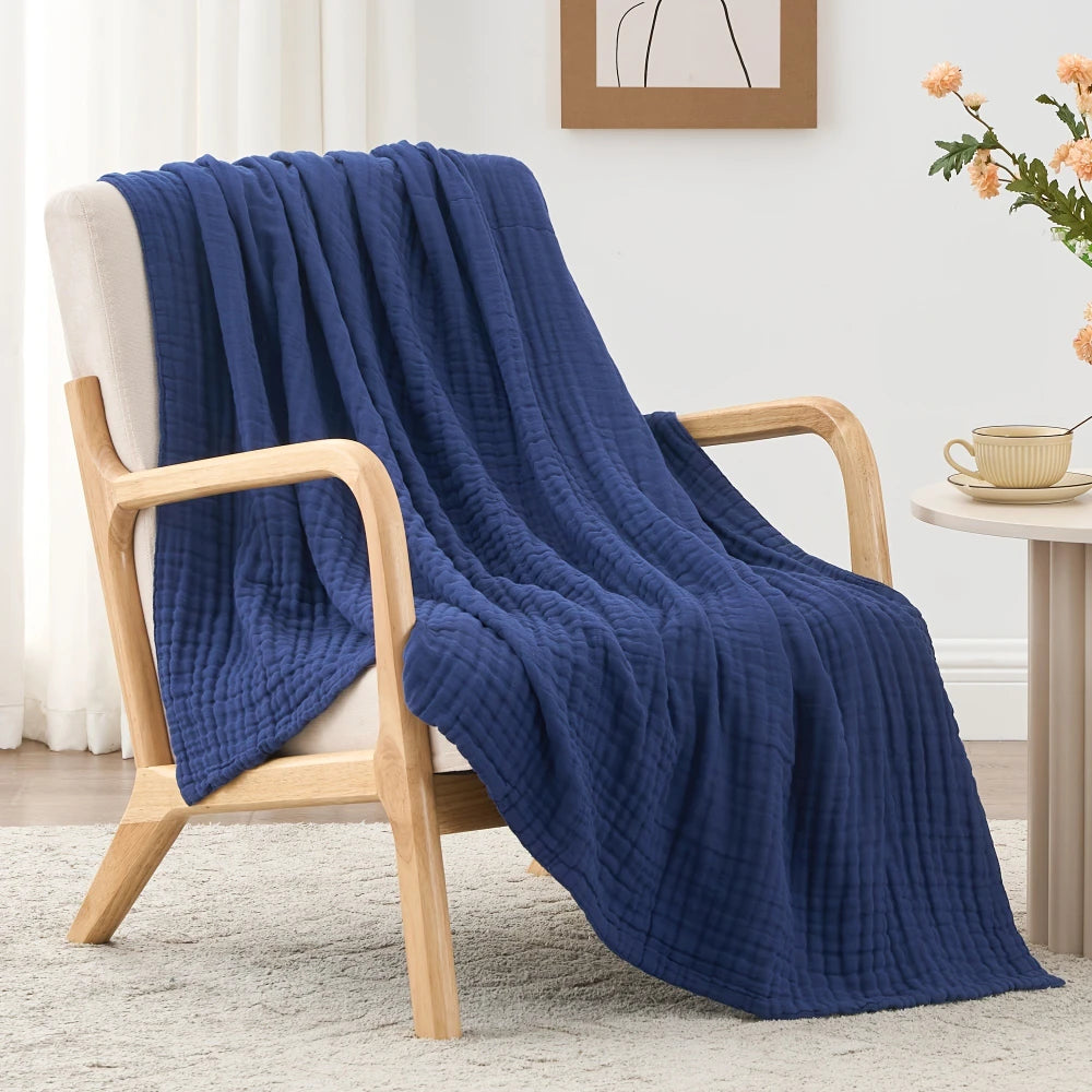 Tiefblaue gesteppte Decke über einem Holzstuhl auf einem hellen Teppich.
