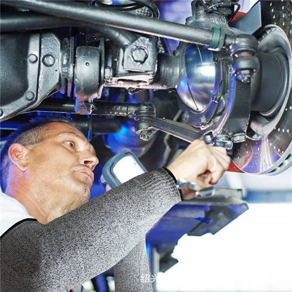 A man wearing a grey sleeve is adjusting or inspecting industrial safety cut-resistant arm sleeves on machinery.