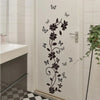 A white door features a black floral vine and butterfly design as a self-adhesive decorative vinyl wall sticker.