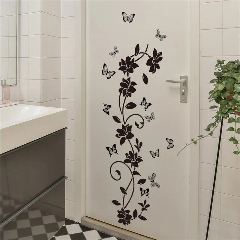 A white door features a black floral vine and butterfly design as a self-adhesive decorative vinyl wall sticker.