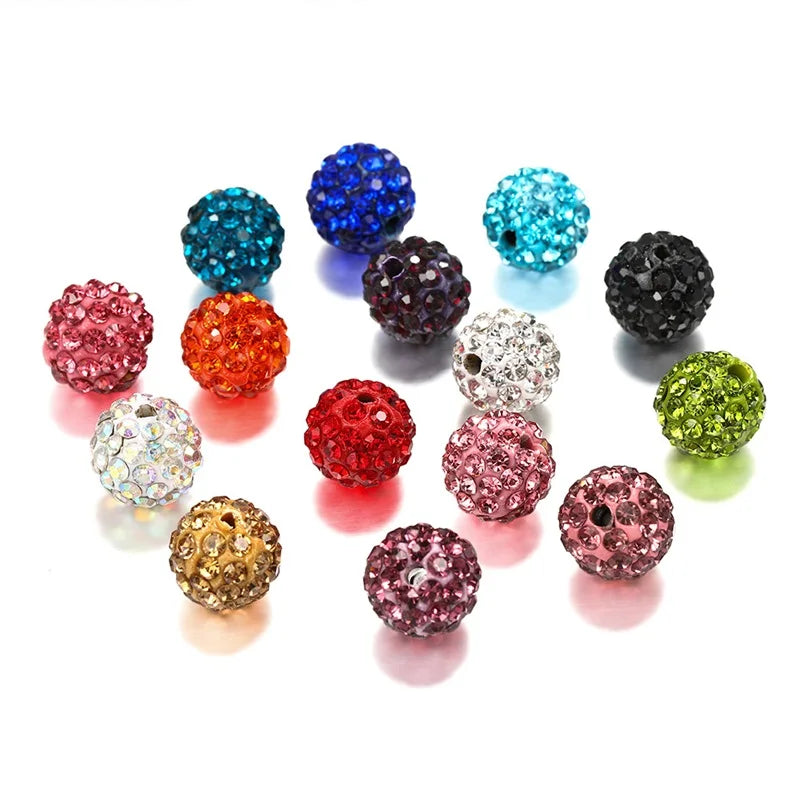 A collection of colorful crystal clay round beads in various shades including blue, purple, pink, orange, and green.