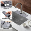 A silicone kitchen sink mat with a faucet splash guard is shown installed on a kitchen sink.