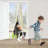 A young boy is running past a large glass screen door with a dog visible inside.