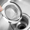 A hand is holding a stainless steel sink strainer mesh, showing the perforated metal filter for draining.