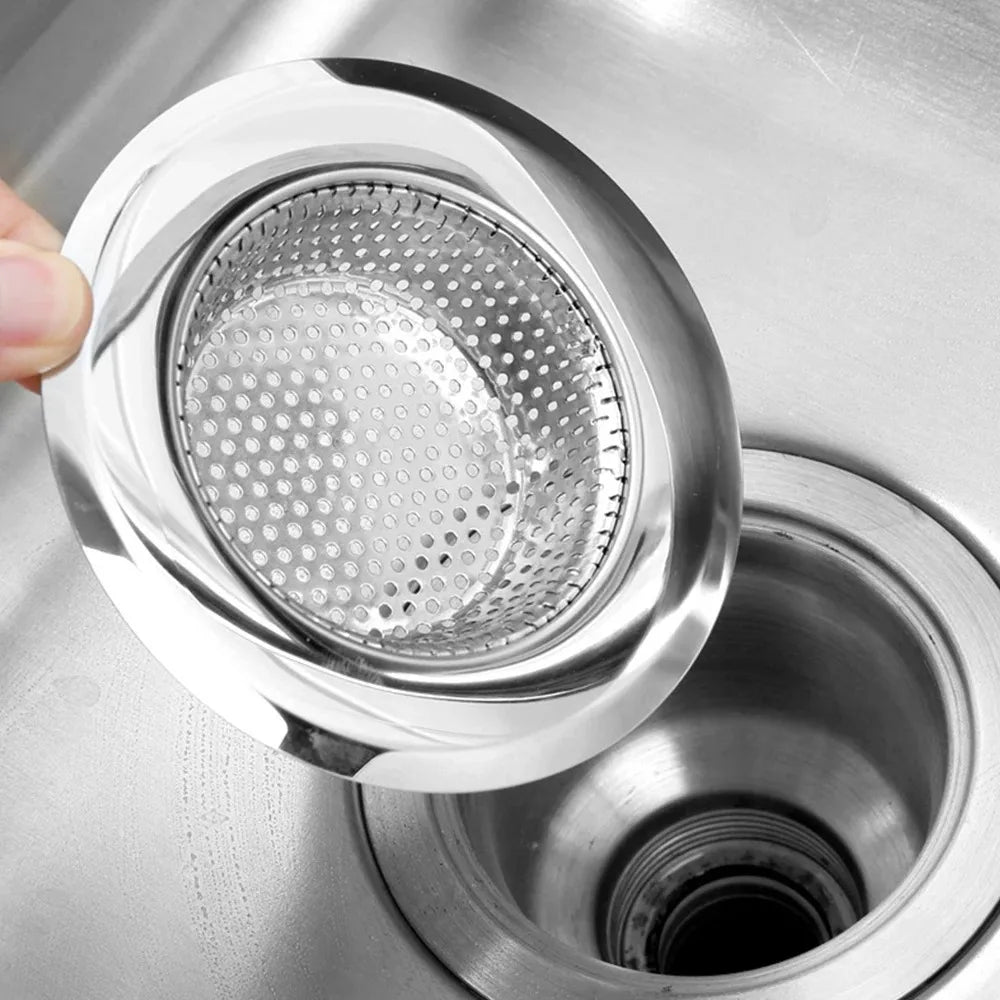 A hand is holding a stainless steel sink strainer mesh, showing the perforated metal filter for draining.