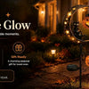 A decorative glow featuring a solar-powered black cat and pumpkin garden stake light illuminating a pathway.