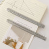 A close-up of an aluminium triangular scale ruler used for precision marking in drafting and crafts.