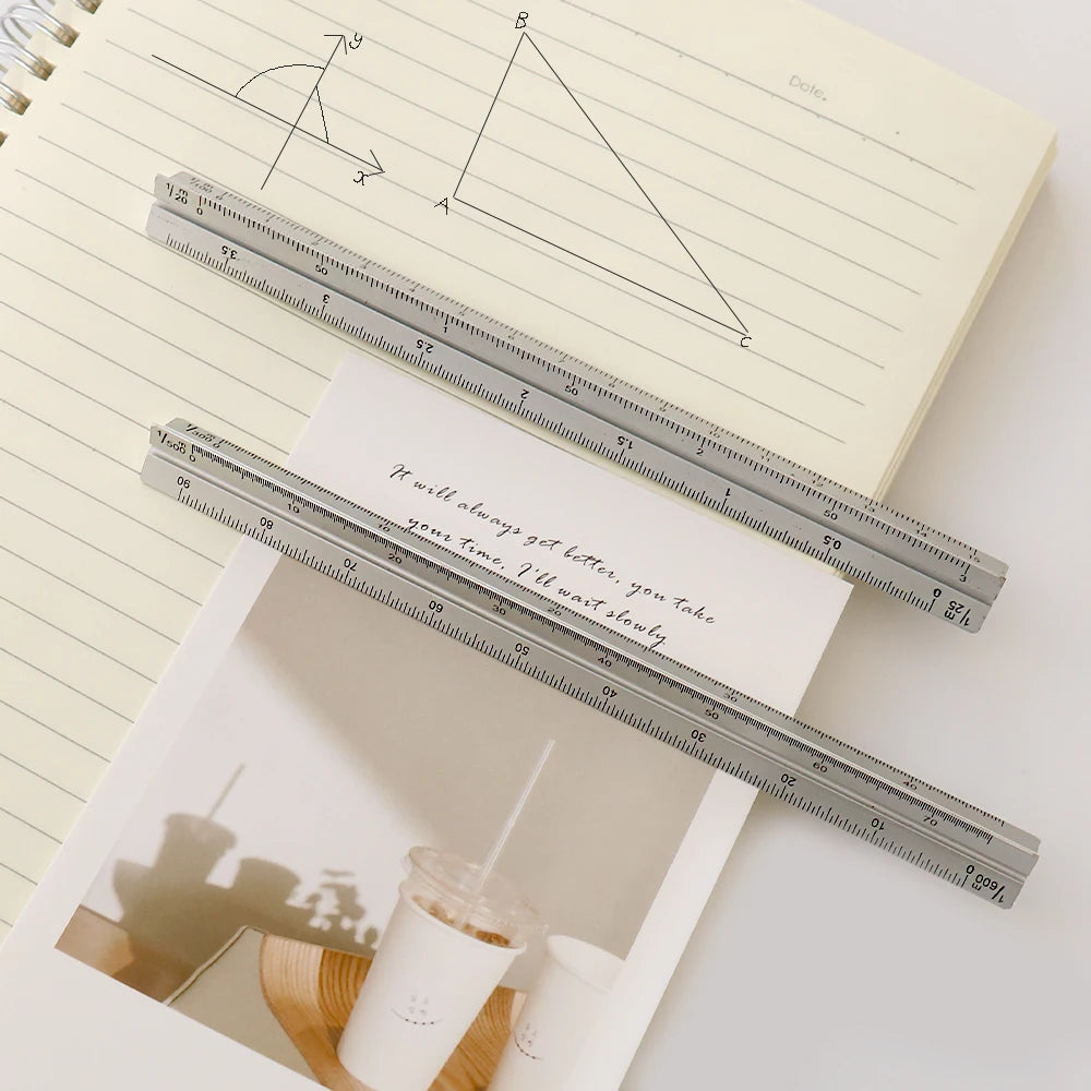 A close-up of an aluminium triangular scale ruler used for precision marking in drafting and crafts.