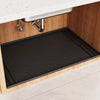 A black silicone mat is placed inside an under sink cabinet to protect the surface.