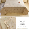 A beige floral quilted bedspread with small gold accents displayed on a bed.