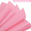 Pink thickened coated paper sheets stacked and laid out for crafting or scrapbooking