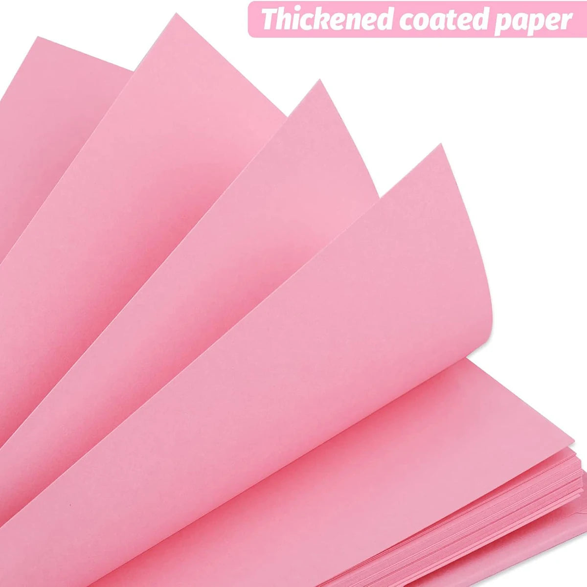 Pink thickened coated paper sheets stacked and laid out for crafting or scrapbooking