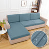 A light blue waterproof sofa cushion cover with an elastic edge resting on a beige sofa.