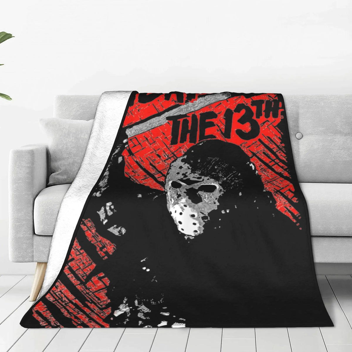 A black and red graphic fleece throw blanket featuring a skull design with the text The 13th.