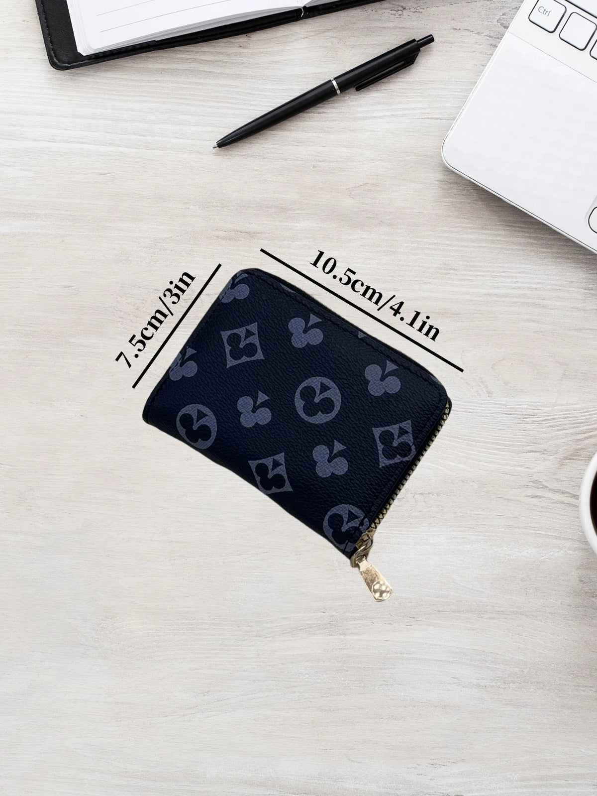 A dark blue compact zippered card holder wallet is shown on a light wooden surface with dimension lines.