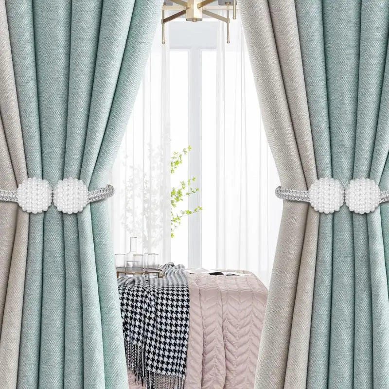 A set of eight pearl magnetic curtain tie-back clips used to hold light blue and beige curtains.