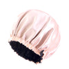 A light pink satin sleep bonnet with a black trim and ruffled edge.