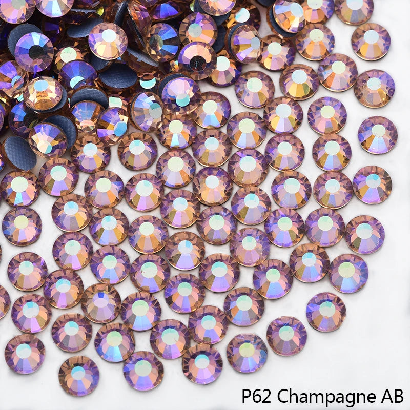 Close-up of iridescent champagne-colored rhinestones scattered on a white background.