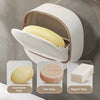 A white hanging soap holder with a drainage feature displaying handmade, face, and regular soaps.