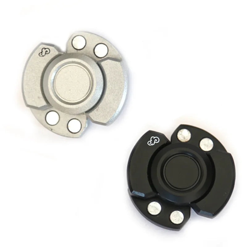 A stainless steel fidget spinner and slider with a round top and multiple small holes.