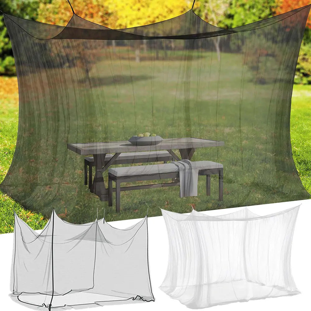 A large mesh fly net canopy is shown draped over a wooden table set in a grassy outdoor setting.