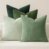 A grouping of three vertical ribbed throw pillows in shades of sage green and pale mint green.