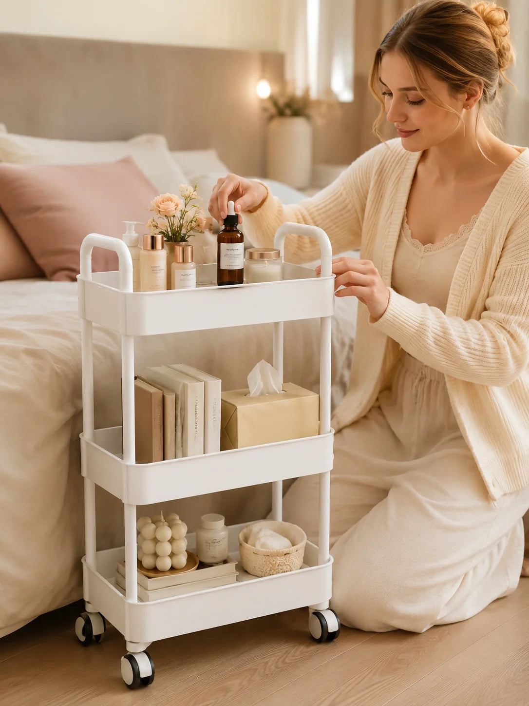 A woman is using a white 3-tier rolling utility cart with wheels for storage in a bright room.