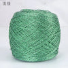 A ball of metallic silk crochet yarn in a vibrant green color for knitting and macrame.
