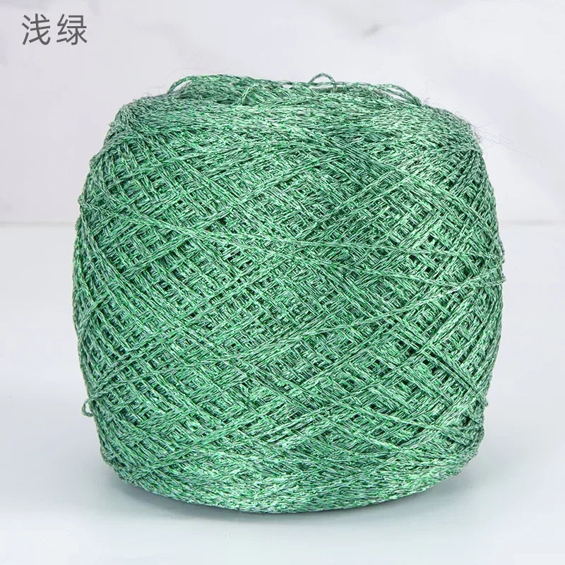 A ball of metallic silk crochet yarn in a vibrant green color for knitting and macrame.