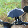 A black mini motorcycle phone umbrella is shown in an outdoor setting.