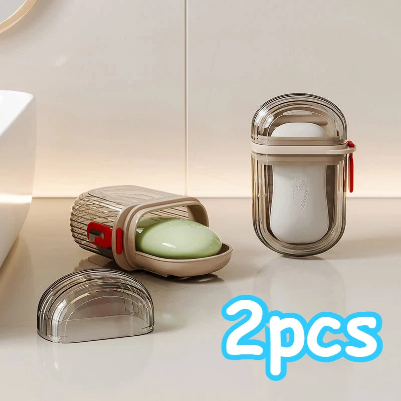 Two clear glass portable travel soap boxes with drainage lids and white soap inside