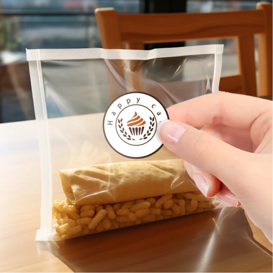 A hand is holding a clear plastic bag containing a rolled pastry and a pile of golden cylindrical food items.