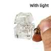 A clear plastic LED mechanical keychain fidget toy with custom keycaps being held by a finger.