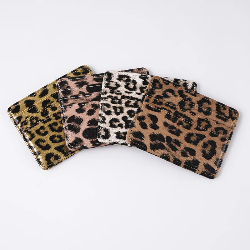 A stack of classic leopard print PU leather card wallets in various shades of brown and black.