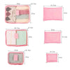 A set of six pink and pastel colored fabric packing cubes shown in various sizes and angles.