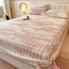 A cozy faux fur fitted sheet in a blush pink color is displayed on a bed with white headboard and soft lighting.