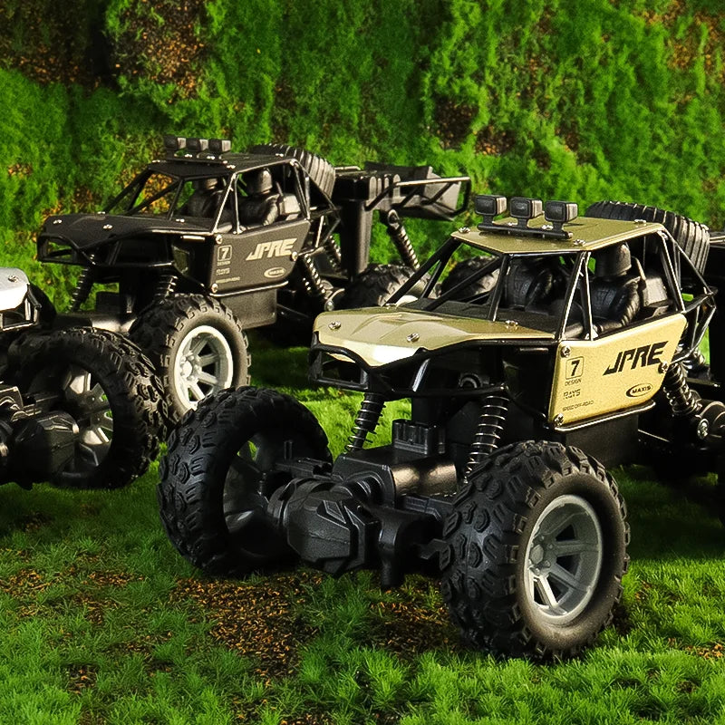 A green and black six-wheel drive off-road RC car is parked on a grassy field with a green hedge background.