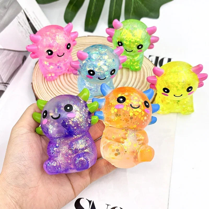 A collection of colorful axolotl squishy stress balls in pink, blue, green, and yellow are displayed on a wooden surface.
