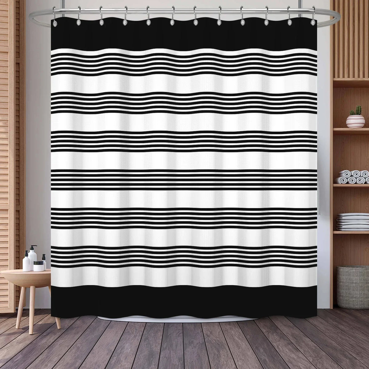Black and white geometric stripe pattern shower curtain hanging on a rod