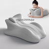 A woman is using a gray ergonomic memory foam wedge pillow for prone sleeping or reading.