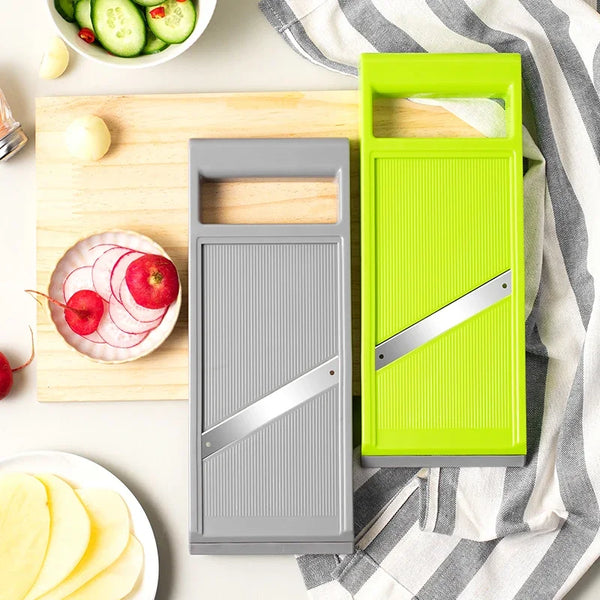 A bright lime green handheld kitchen vegetable cutter and a gray version are displayed on a wooden cutting board.