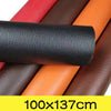 A roll of black PU leather patch next to several rolls of brown, red, and orange leather.
