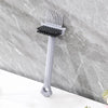 A gray dual-sided hairbrush cleaner with rake teeth is shown against a marbled background.