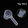 Clear plastic measuring cup with a long spout shown against a black background.