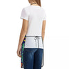 White t-shirt with a black floral art apron tied around the waist, worn over dark blue jeans.